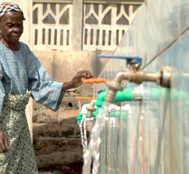 Woman in Ola community fetching clean drinkable water